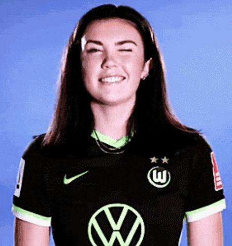 a woman wearing a black and green nike shirt with a vw logo on it