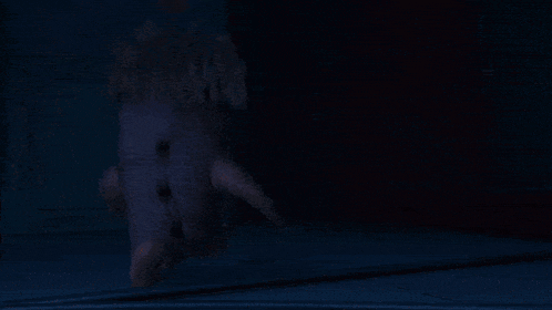 a ghostly figure is walking through a doorway at night