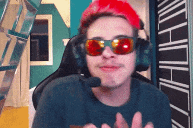 a man wearing red sunglasses and a red hat with a microphone on his head