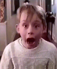 a young boy with his mouth open is wearing a white sweater and a hat .