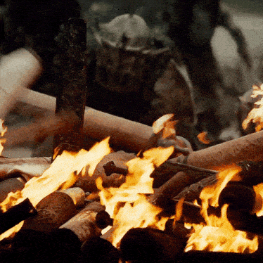 a man in a helmet stands behind a pile of fire