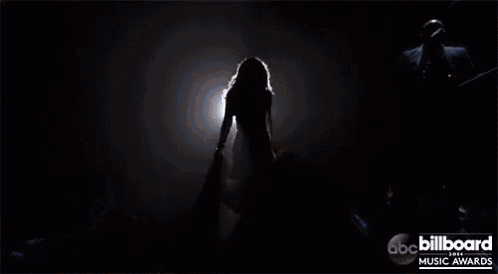 a silhouette of a woman dancing on a stage with the words abc billboard music awards on the bottom
