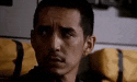 a close up of a man 's face sitting in a chair with a yellow bag .
