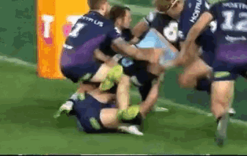 a group of rugby players are playing on a field and one player has the number 15 on his jersey