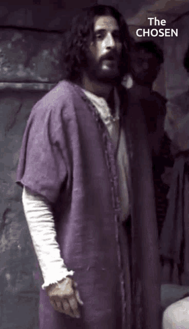 a man in a purple robe with the words " the chosen " behind him