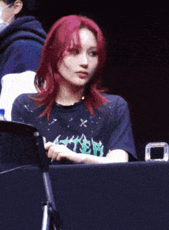 a woman with red hair is wearing a black shirt that says ' aster ' on it