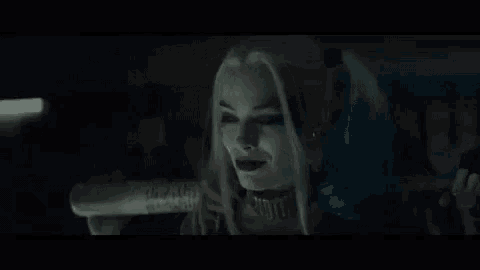 harley quinn from suicide squad is holding a bat in her hand and says pussy .