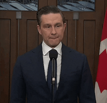 a man in a suit speaking into a microphone