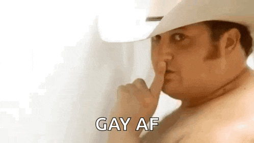 a shirtless man in a cowboy hat is holding his finger to his nose and saying `` gay af '' .