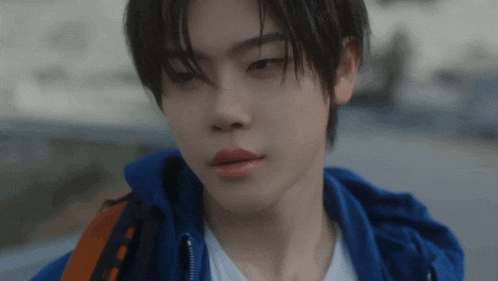 a close up of a person wearing a blue jacket and white shirt