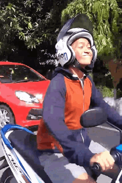 a man wearing a helmet with the word vision on it rides a motorcycle