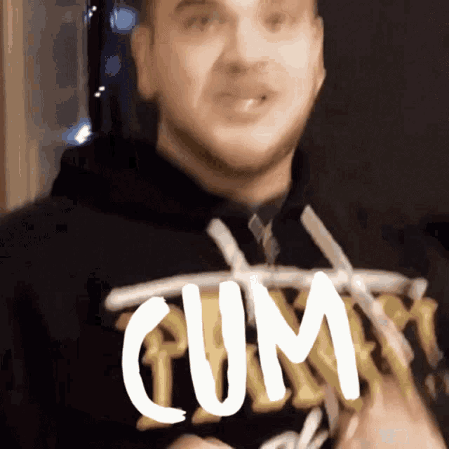 a man wearing a black shirt that says cum