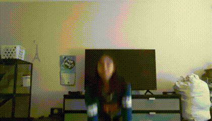 a woman is dancing in a living room in front of a television .