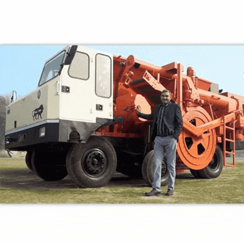 a man stands in front of a large truck that says rr on it