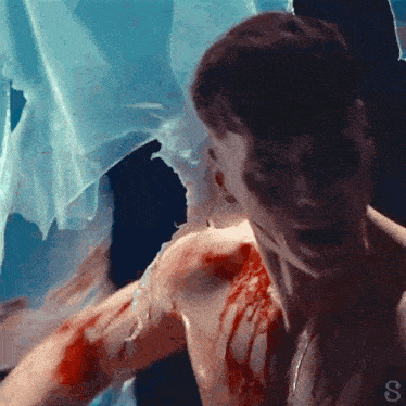 a close up of a man 's face with blood dripping from it