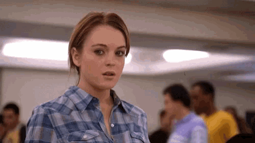 a girl wearing a plaid shirt looks surprised