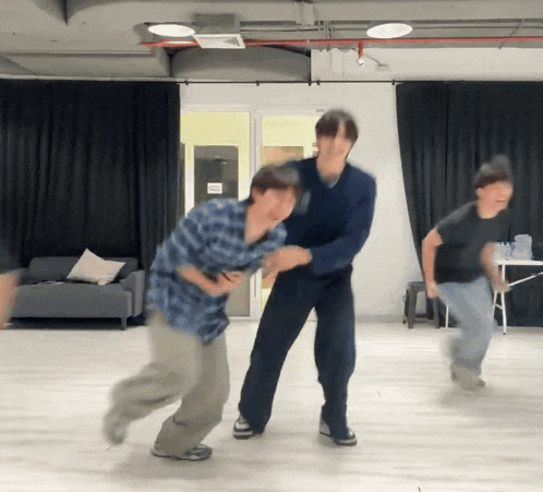 a man in a blue plaid shirt is holding another man 's arm
