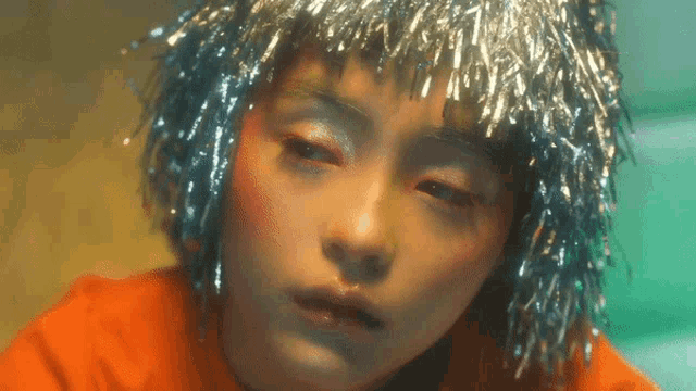 a close up of a woman 's face with tinsel on her hair