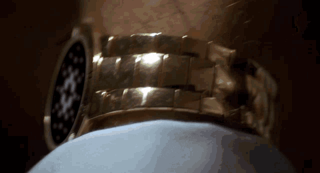 a close up of a gold watch on a man 's arm