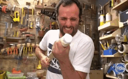 a man is making a funny face while holding a bottle of glue .