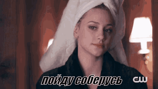 a woman with a towel wrapped around her head is wearing a bathrobe .