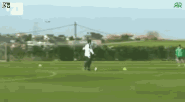 a man in a white jacket is kicking a soccer ball
