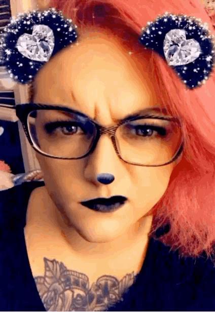 a woman with pink hair is wearing glasses and rhinestone ears