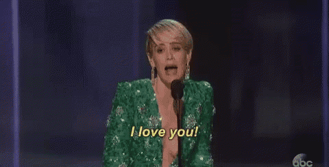 a woman in a green jacket is standing in front of a microphone and says `` i love you '' .