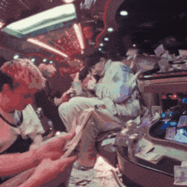a group of people are sitting in a room with a lot of money