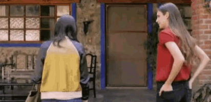 two women are standing next to each other in front of a door .