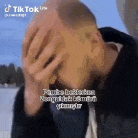 a man is covering his face with his hands in a tik tok video