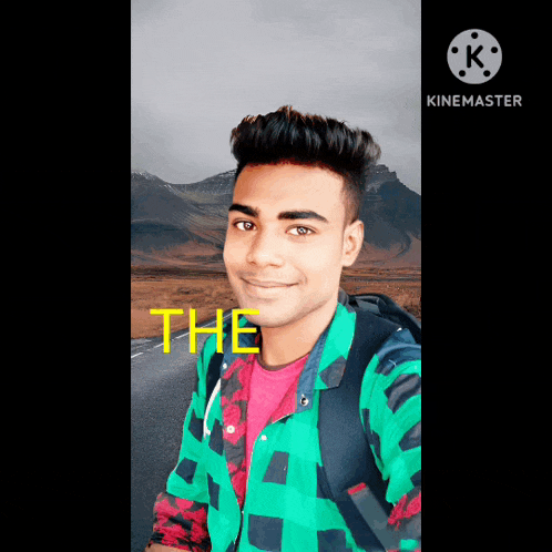 a young man in a green plaid shirt is smiling in front of a road with the word the written on it