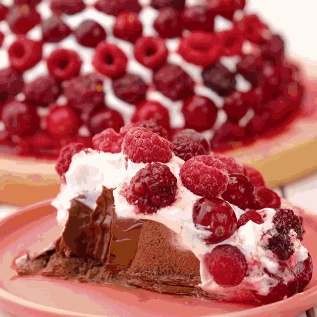 a slice of cake with raspberries and whipped cream on a plate