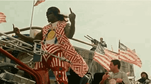 a man in a red white and blue outfit is giving a middle finger