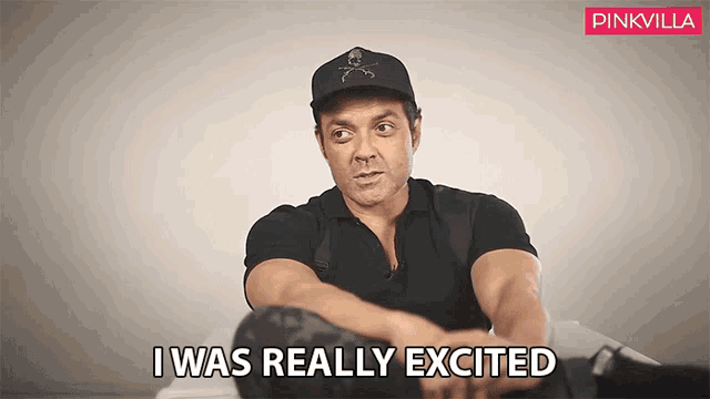 a man wearing a black hat is sitting down and says i was really excited