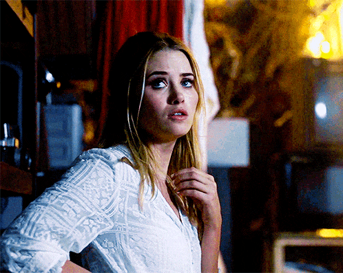 a woman in a white shirt is standing in front of a television