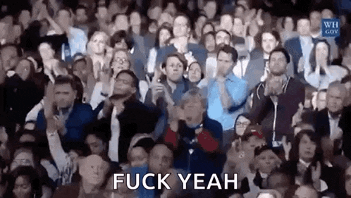 a crowd of people applauding in a stadium with the words `` fuck yeah '' written above them .