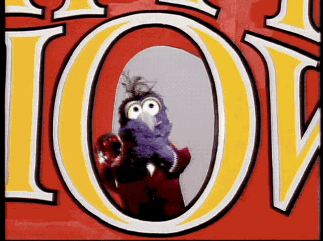 a purple bird is standing in front of a large yellow letter o