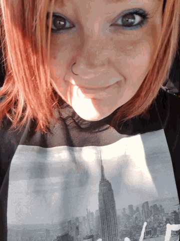 a woman wearing a black shirt with a picture of the empire state building
