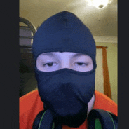 a man wearing a black mask and headphones looks at the camera