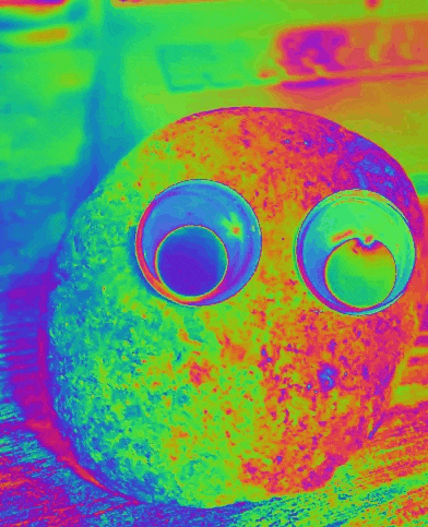 a colorful image of a rock with googly eyes on it .
