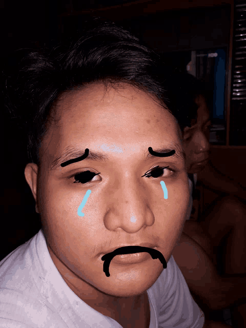 a man with tears coming out of his eyes and a mustache drawn on his face
