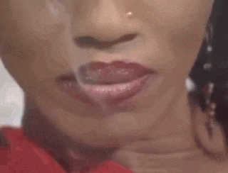 a close up of a woman 's face with a nose ring and red lipstick .