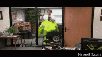 a man in a yellow jacket is standing in front of a door in an office ..