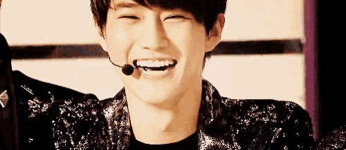 a man with a microphone in his mouth smiles