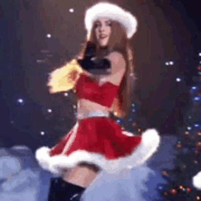 a woman in a santa claus costume is dancing on a stage in front of a christmas tree .