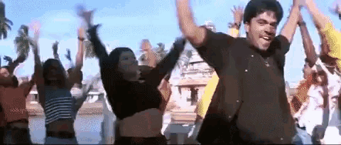 a man and a woman are dancing with their arms in the air