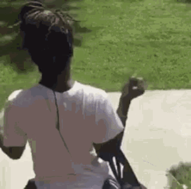 a woman is sitting in a chair wearing headphones and dancing .