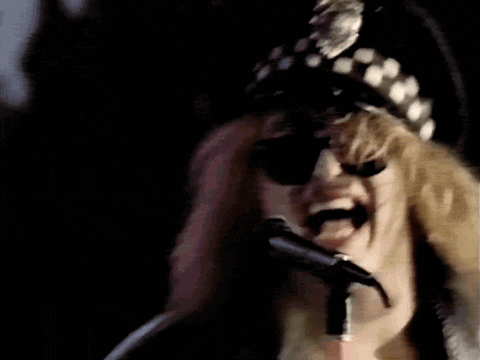 a woman singing into a microphone wearing a police hat and sunglasses
