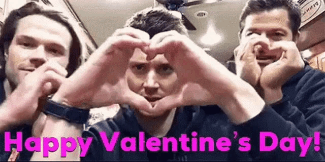 three men are making a heart shape with their hands in a restaurant .